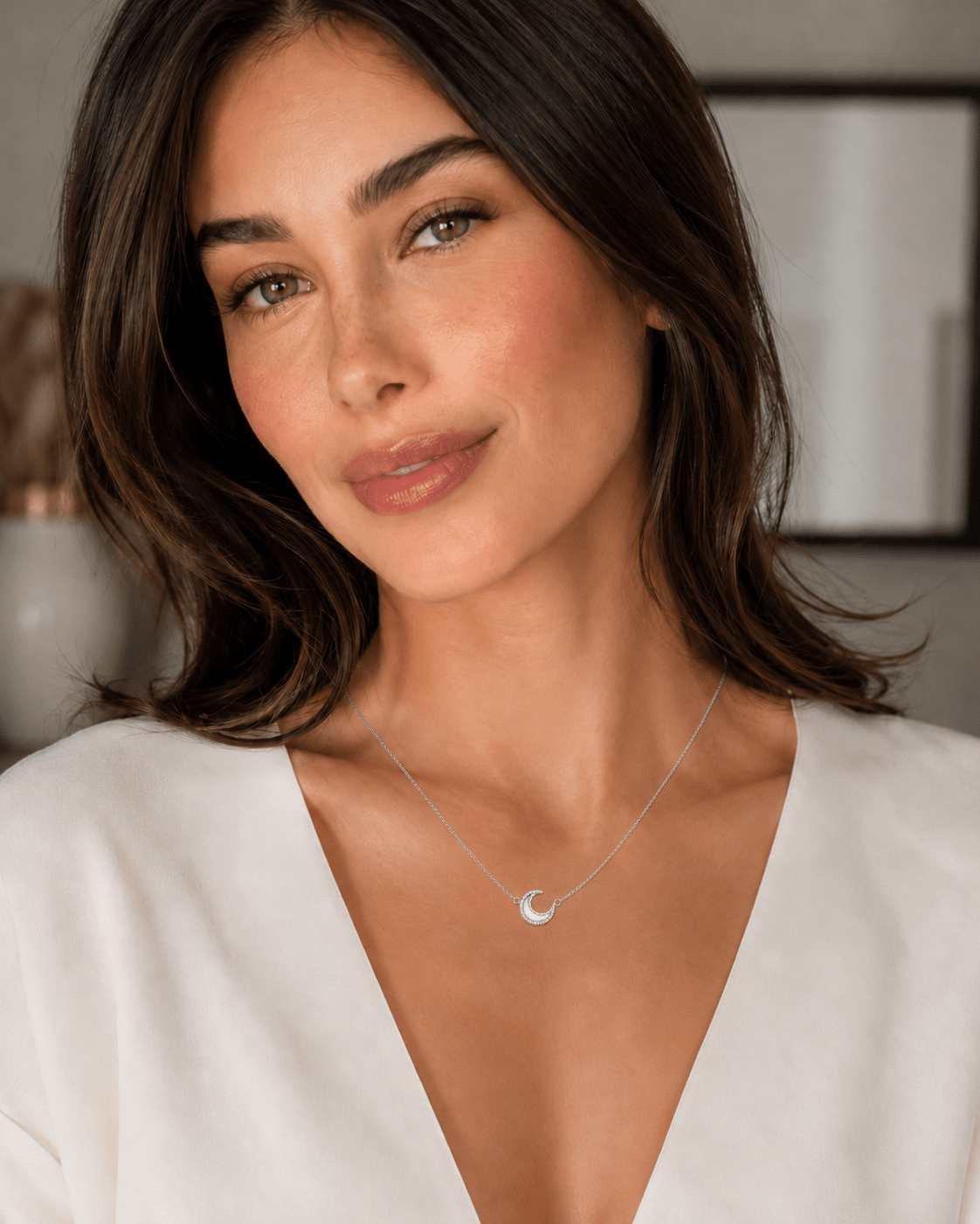 A woman wearing the Nina Crystal Moon Necklace in silver, close-up portrait.