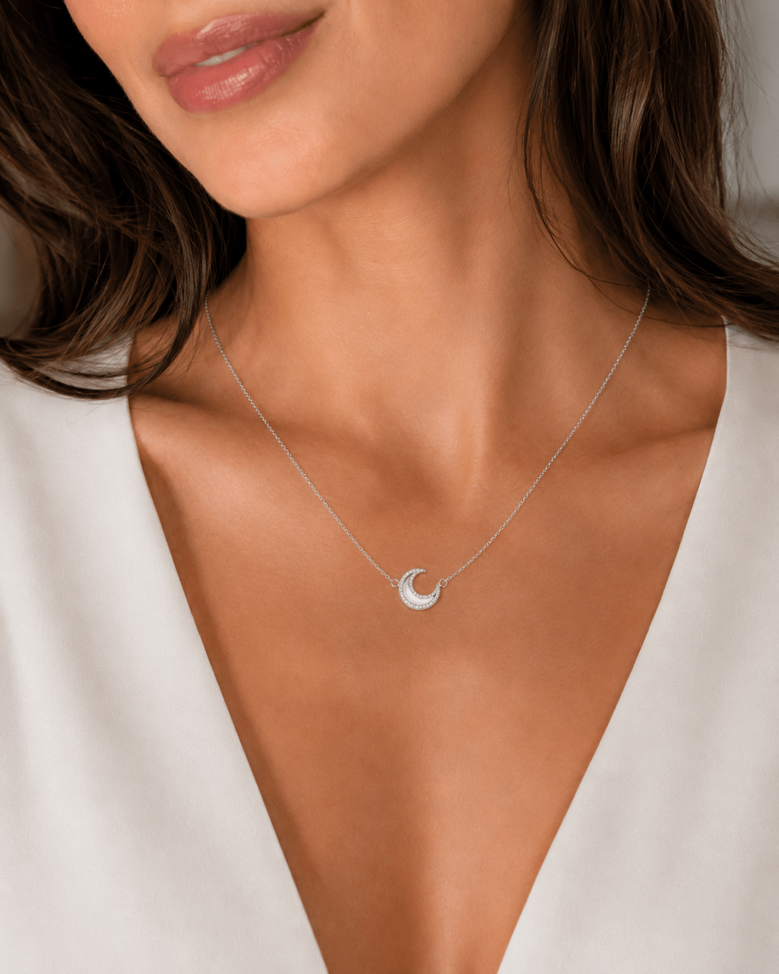 Close-up of a woman wearing the Nina Crystal Moon Necklace in silver, pendant resting at the collarbone.