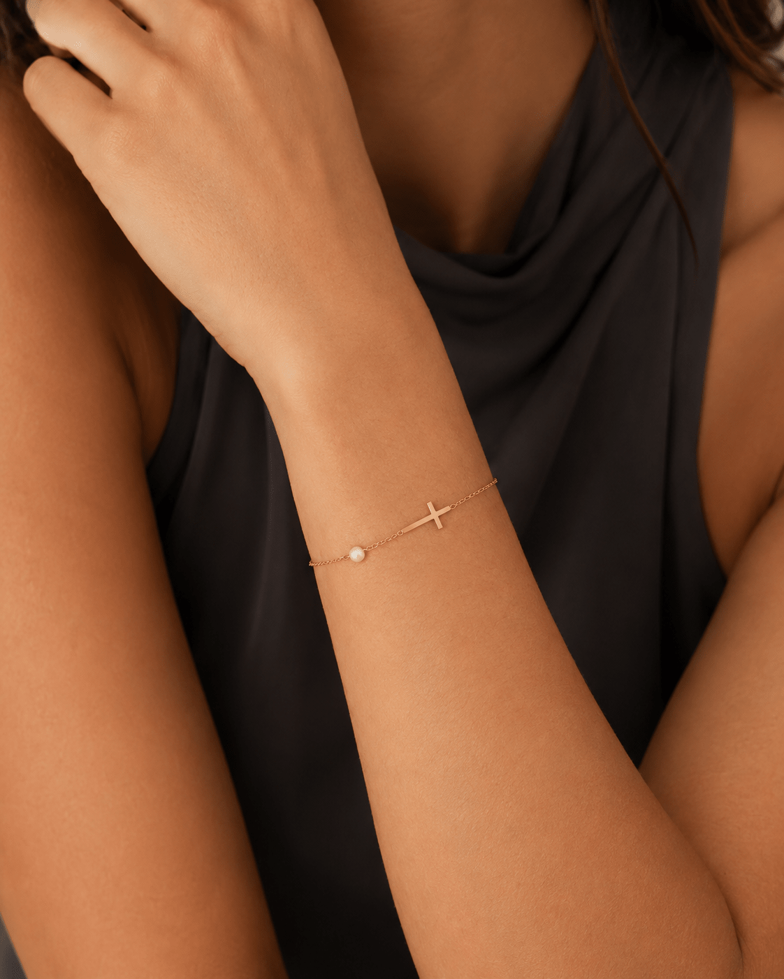 Woman wearing the Veritas Gold Cross Bracelet