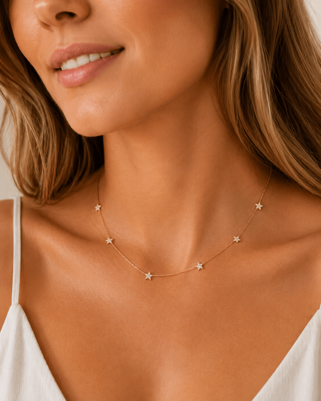 Side view of Lola gold star station necklace showing the spacing of the star charms