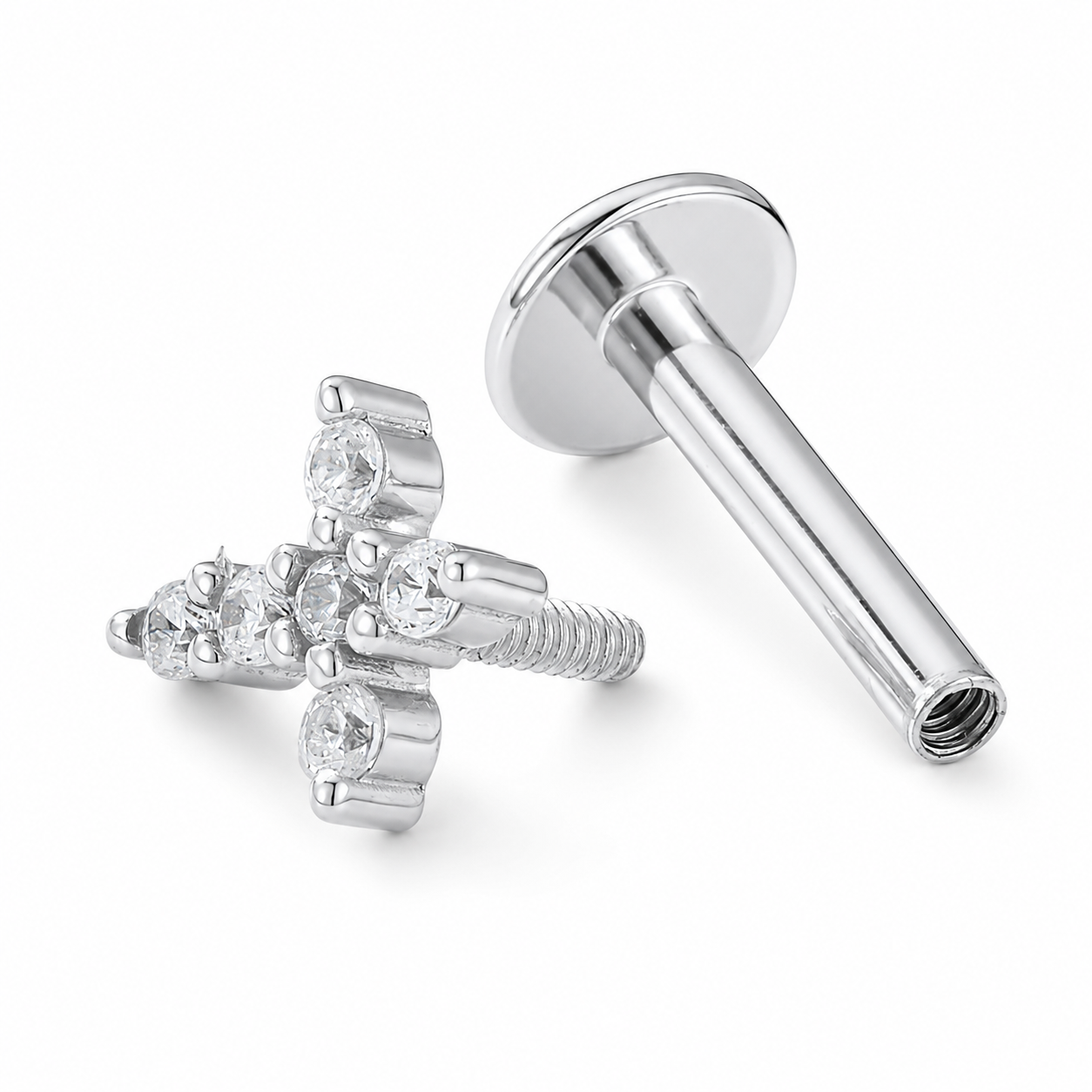 Silver-toned labret piercing stud with a cross-shaped front and clear gemstones, shown alongside the flat back with threaded post on a white background.