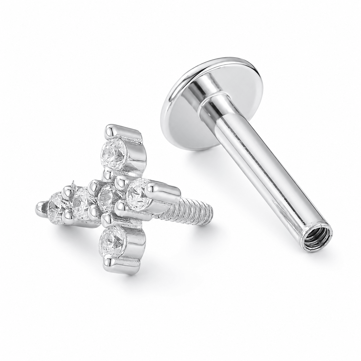 Silver-toned labret piercing stud with a cross-shaped front and clear CZ stones, shown alongside the flat back with threaded post on a white background
