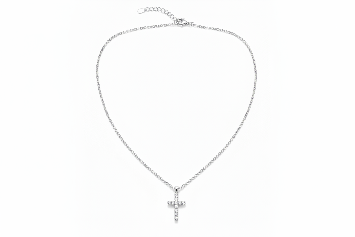 A delicate gold chain necklace with a small cross pendant adorned with clear rhinestones, displayed against a solid white background.
